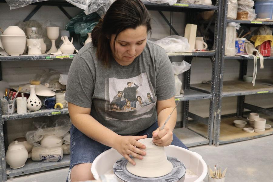 Student working on pottery wheel