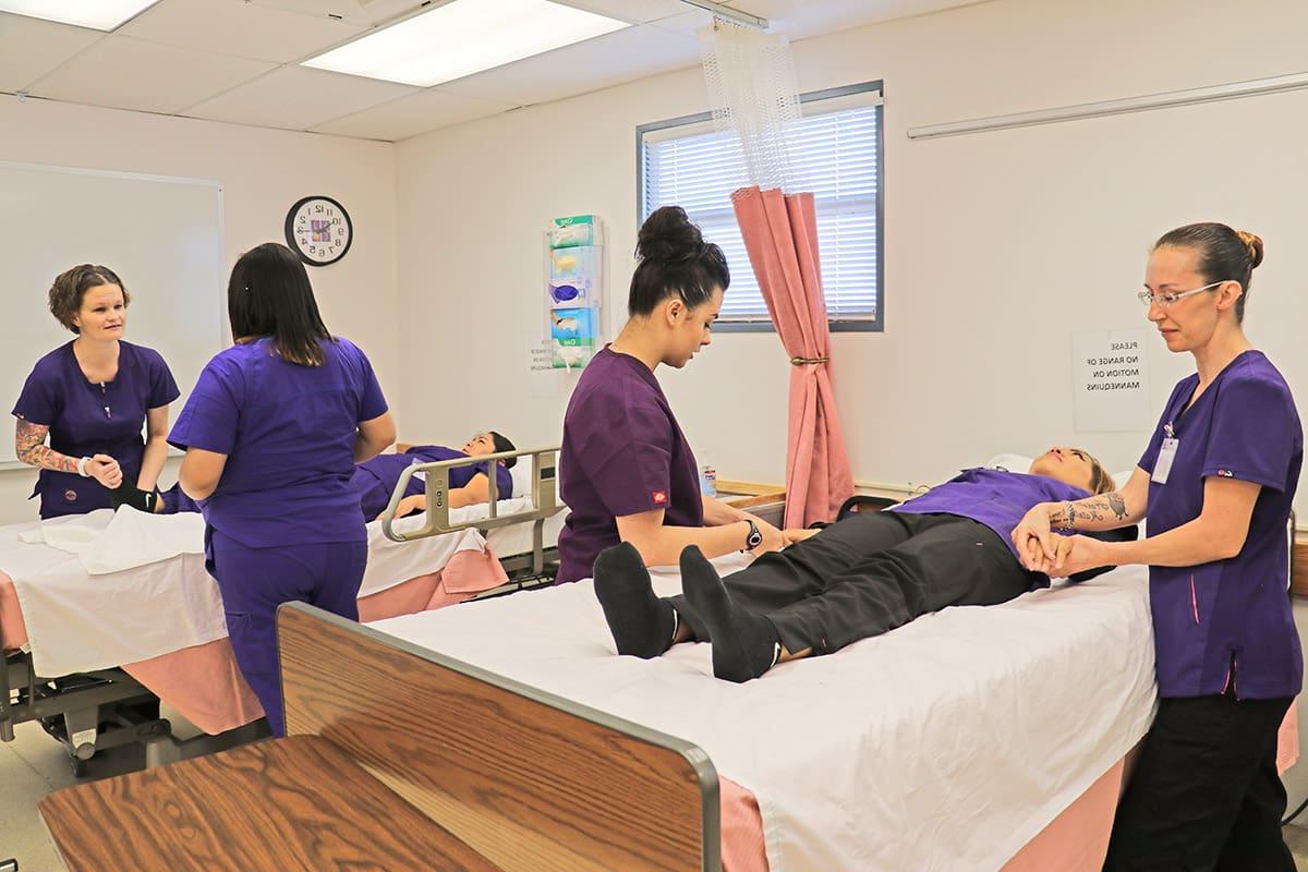 nursing cna students work through exercise on basic patient care.